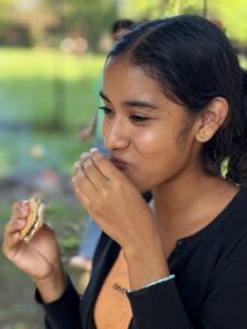 picture of young lady eating a snack and visibly happy