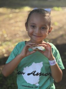 Girl eating a snack with a smile on her face